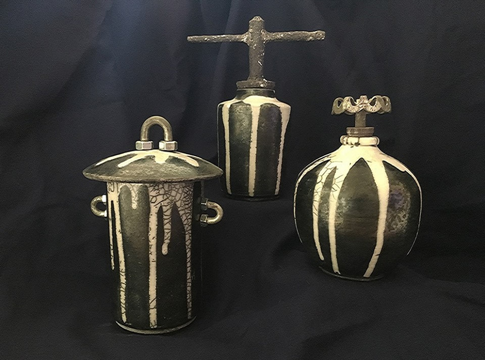 three black pots with dripped white glaze and hardware handles