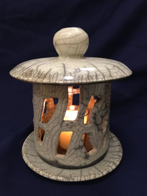 white raku fired candle lit lamp with lid